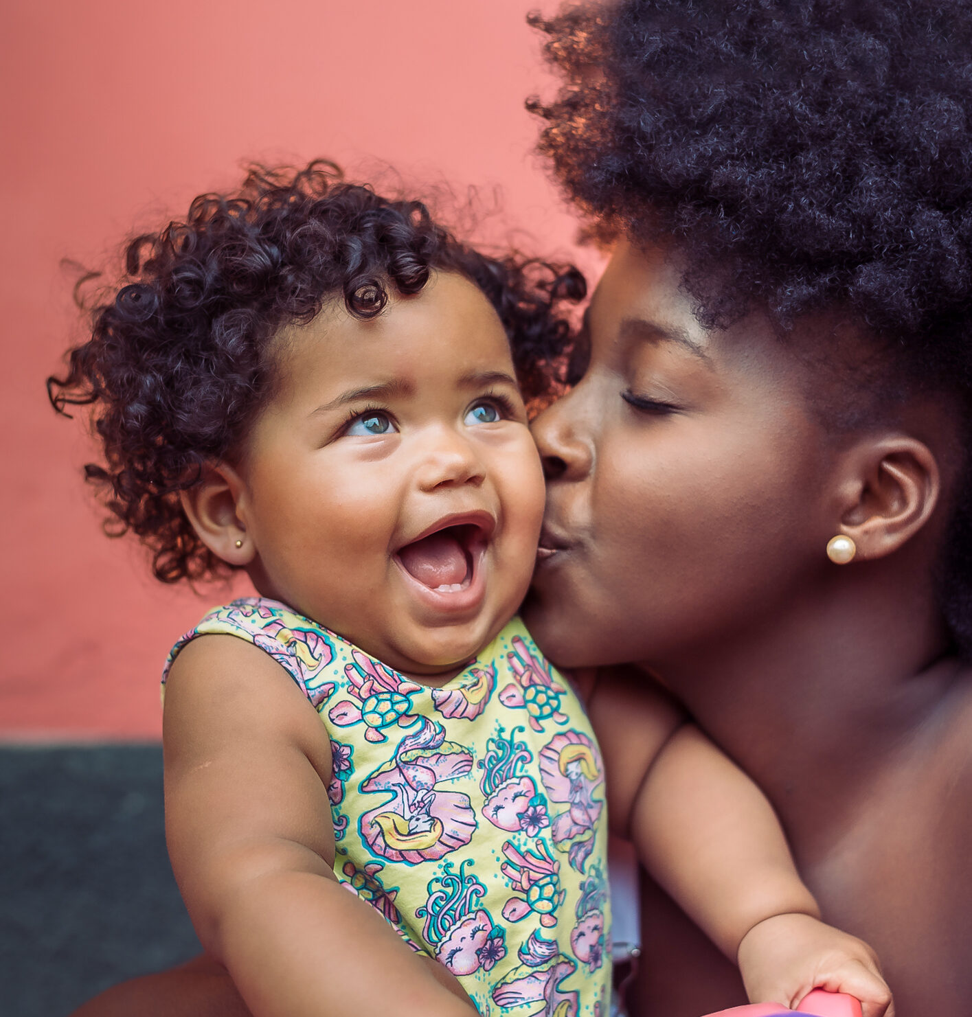 Mother kissing smiling baby girl